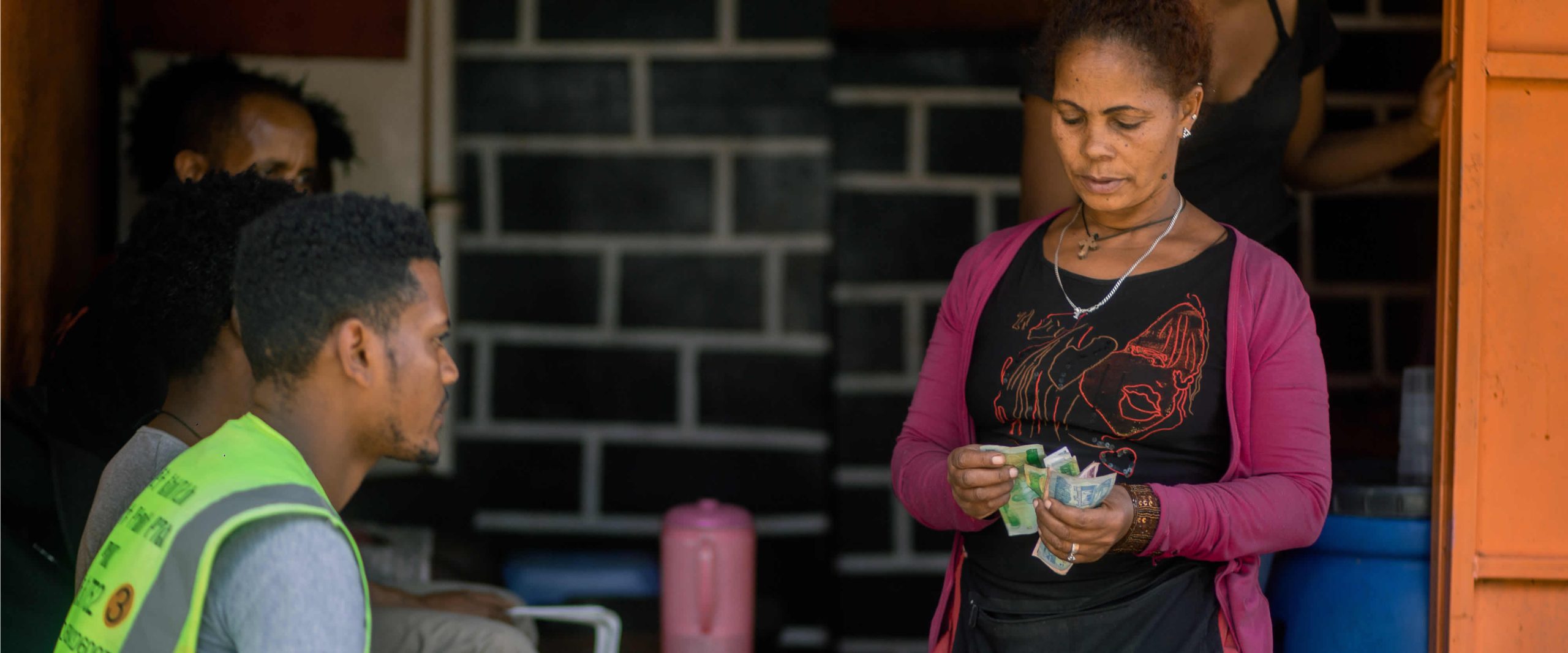 An Ethiopian woman shopkeeper counting cash at her business